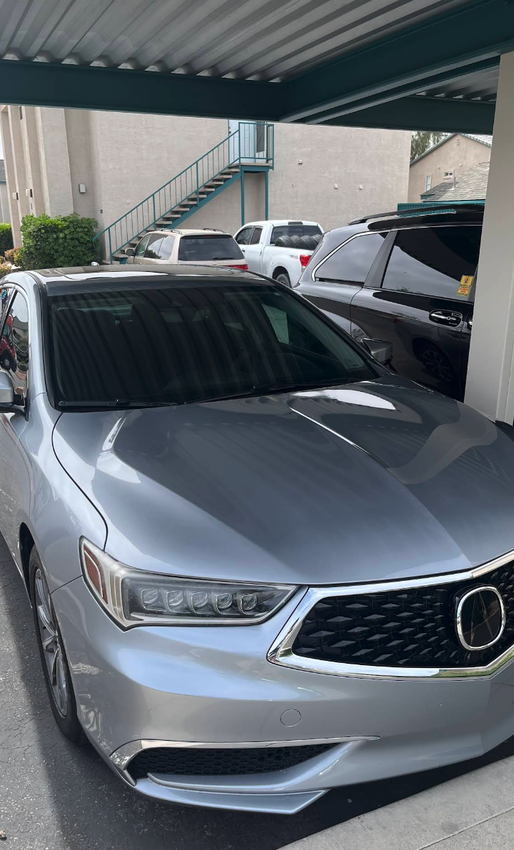 A silver Acura sedan, freshly washed and gleaming under the bay canopy.